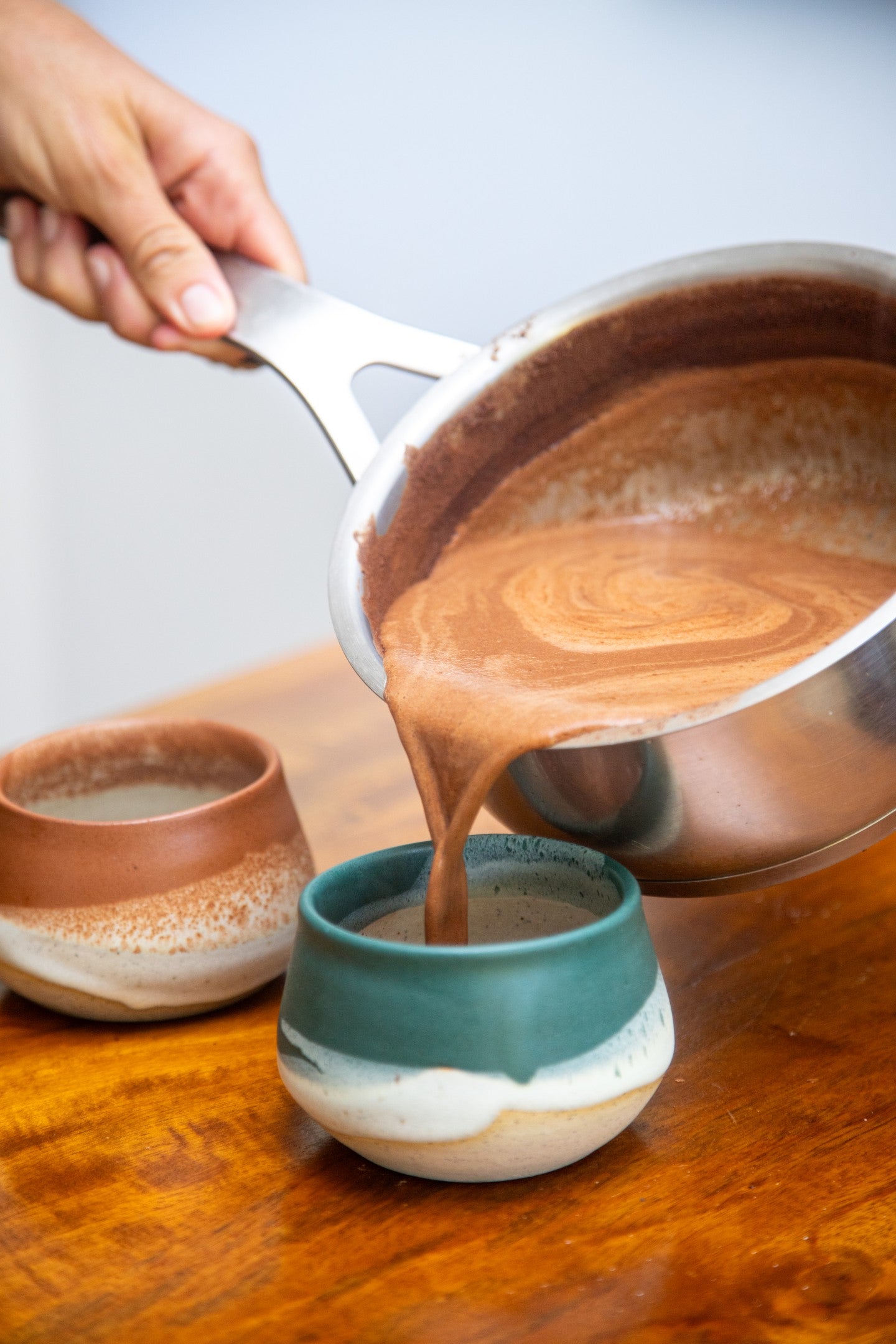 Pouring ceremonial cacao into a cup as part of a calming daily ritual