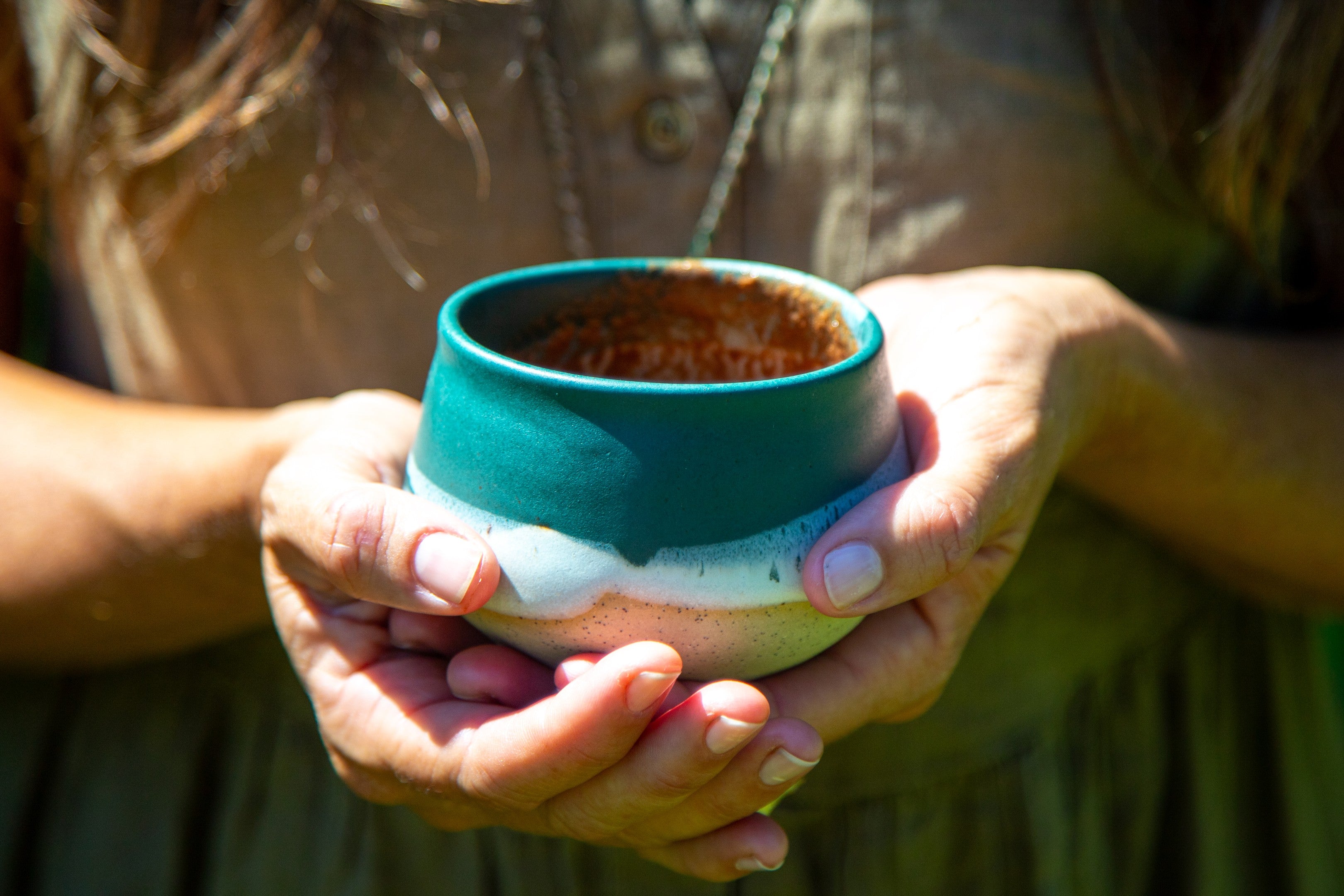 Woman holding a warm cup of ceremonial cacao for a calming daily ritual