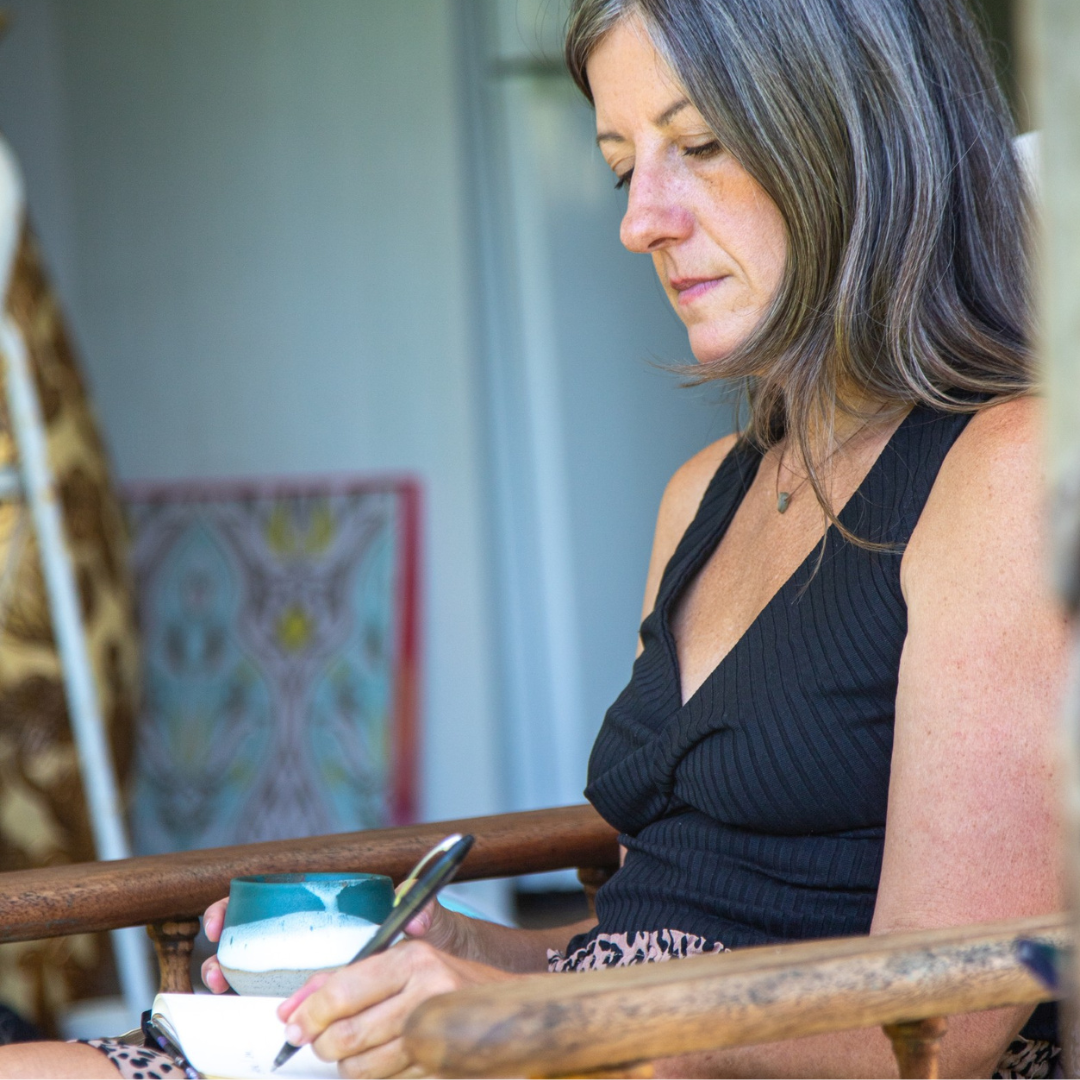 woman drinking cacao and writing in journal creating her life